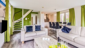 A modern living room with a staircase, a dining area, and a kitchen. - Breskens Haven: Relax, Explore & Dine (Breskens)