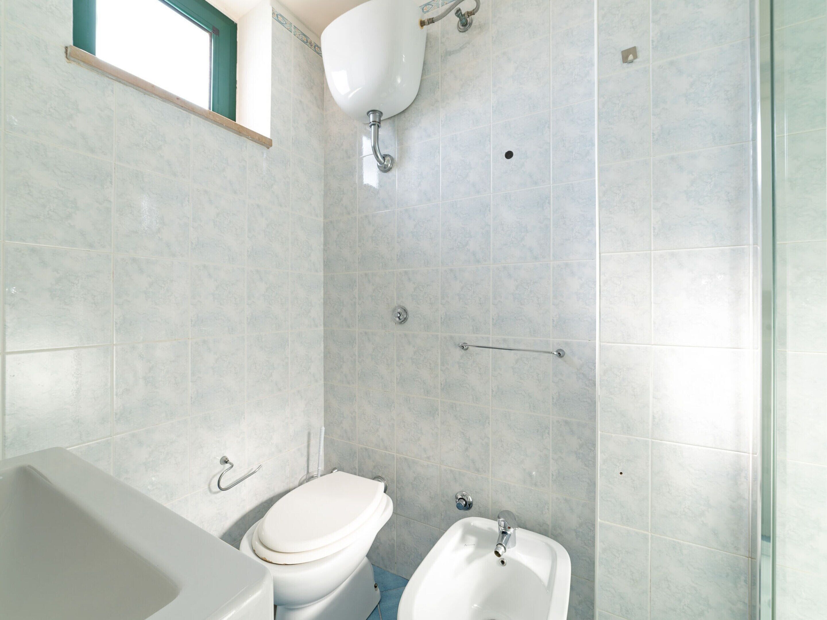 A bathroom with a toilet, bidet, and bathtub.