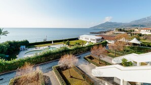 A coastal resort with a swimming pool, a gazebo, and a view of the sea and mountains. - Belvilla by OYO Apartment in Policastro Bussentino (Santa Marina)