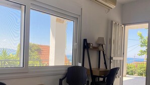 Ett rum med ett bord och stolar, en takfläkt och utsikt genom ett fönster.