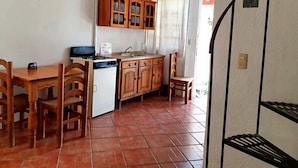 A compact kitchen with wooden cabinets, a stove, and a sink. - Hotel Paraje Casa Blanca (San Agustin Etla)