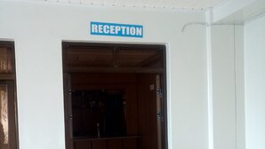 Un área de recepción con un letrero sobre la puerta, paneles de madera en las paredes y suelo de baldosas.