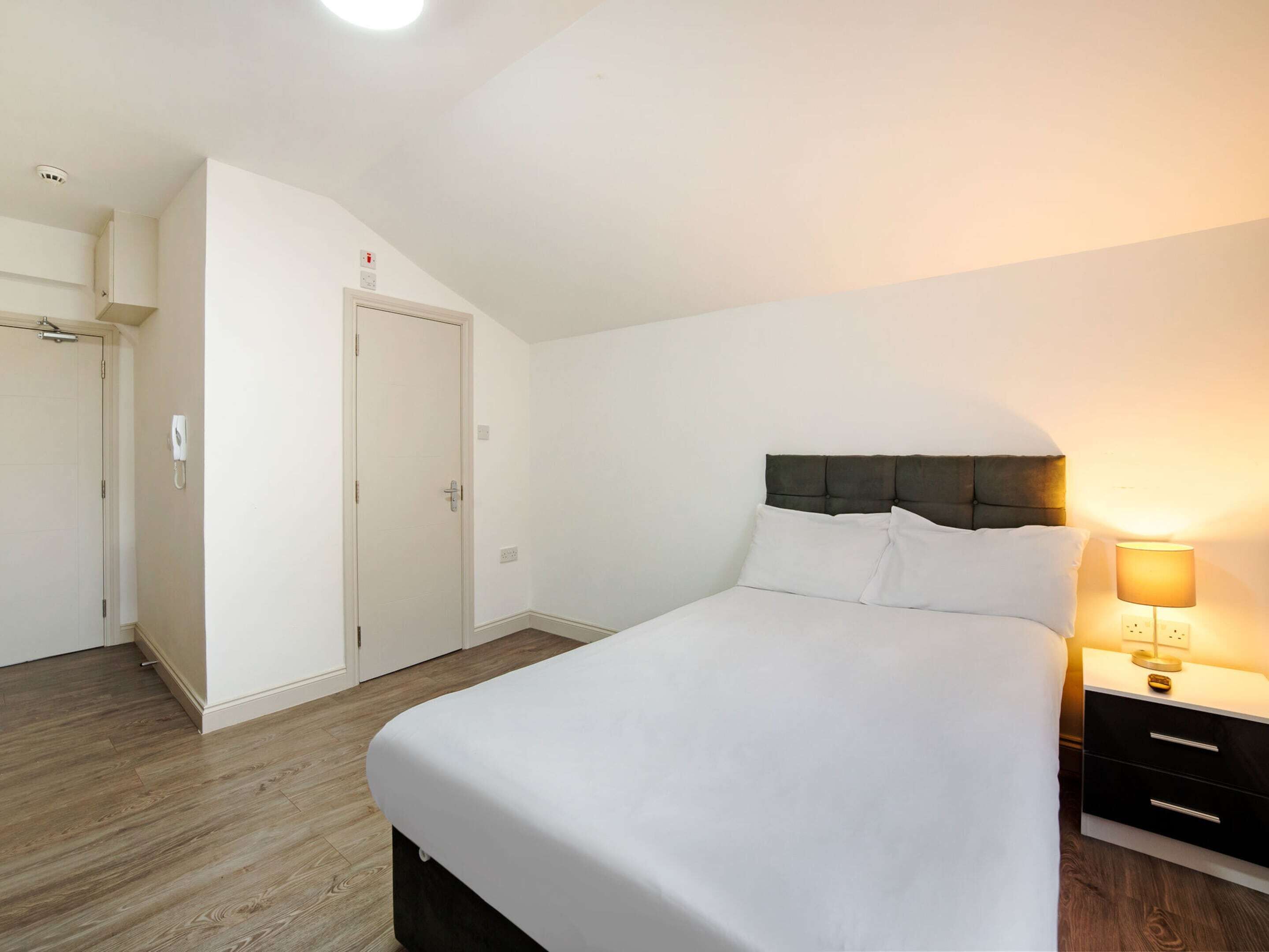 Une chambre à coucher avec un lit, une table de chevet et une armoire.