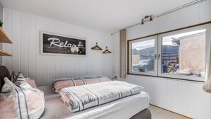 A bedroom with a bed, a window, and a wall-mounted sign. - Bungalow in Wernigerode (Wernigerode)