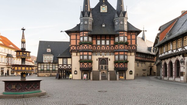 A historic building with a central tower, a courtyard, and traditional half-timbered facades.