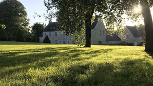 A grassy field with a stone building and trees. - Cozy Normandy Escape (Formigny La Bataille)