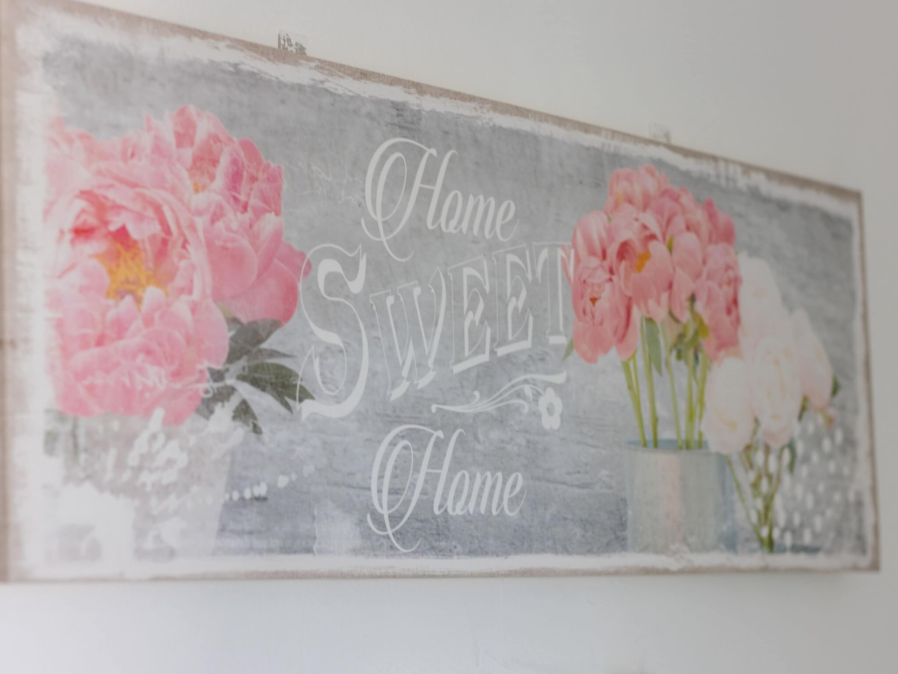 A decorative sign with the phrase "Home Sweet Home" and floral designs.