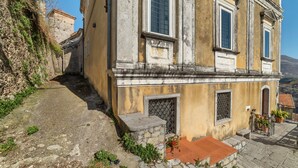 A historic building with a stone staircase leading to a tiled entrance, surrounded by vegetation and a clear sky. - Vintage Holiday Home in Caselle in Pittari near Forest (Caselle in Pittari)