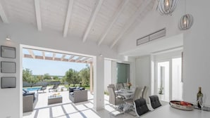 A spacious living area with a patio, a dining area, and a kitchen. - Villa in Debeljak With Pool Near the Sea (Sukosan)