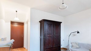 Une pièce comprenant une armoire en bois, un canapé, une lampe et un luminaire au plafond.