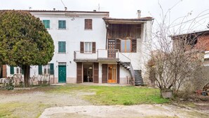 Un bâtiment à deux étages doté d’un balcon, d’un escalier et d’une porte d’entrée.