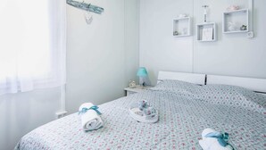 A bedroom with a bed, a nightstand, a lamp, and a wall-mounted shelf with decorative items. - Secluded Holiday Home in Pašman near Sea (Pasman)