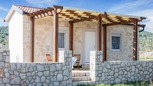 A stone building with a wooden pergola, a door, and two windows. - Secluded Holiday Home in Pašman near Sea (Pasman)