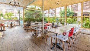 A spacious indoor dining area with wooden flooring, large windows, and modern furniture. - Apart Hotel Tarsis Club (Sunny Beach)