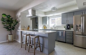 Enjoy cooking in this well-equipped kitchen with a large island, bar stools, and ample counter space.