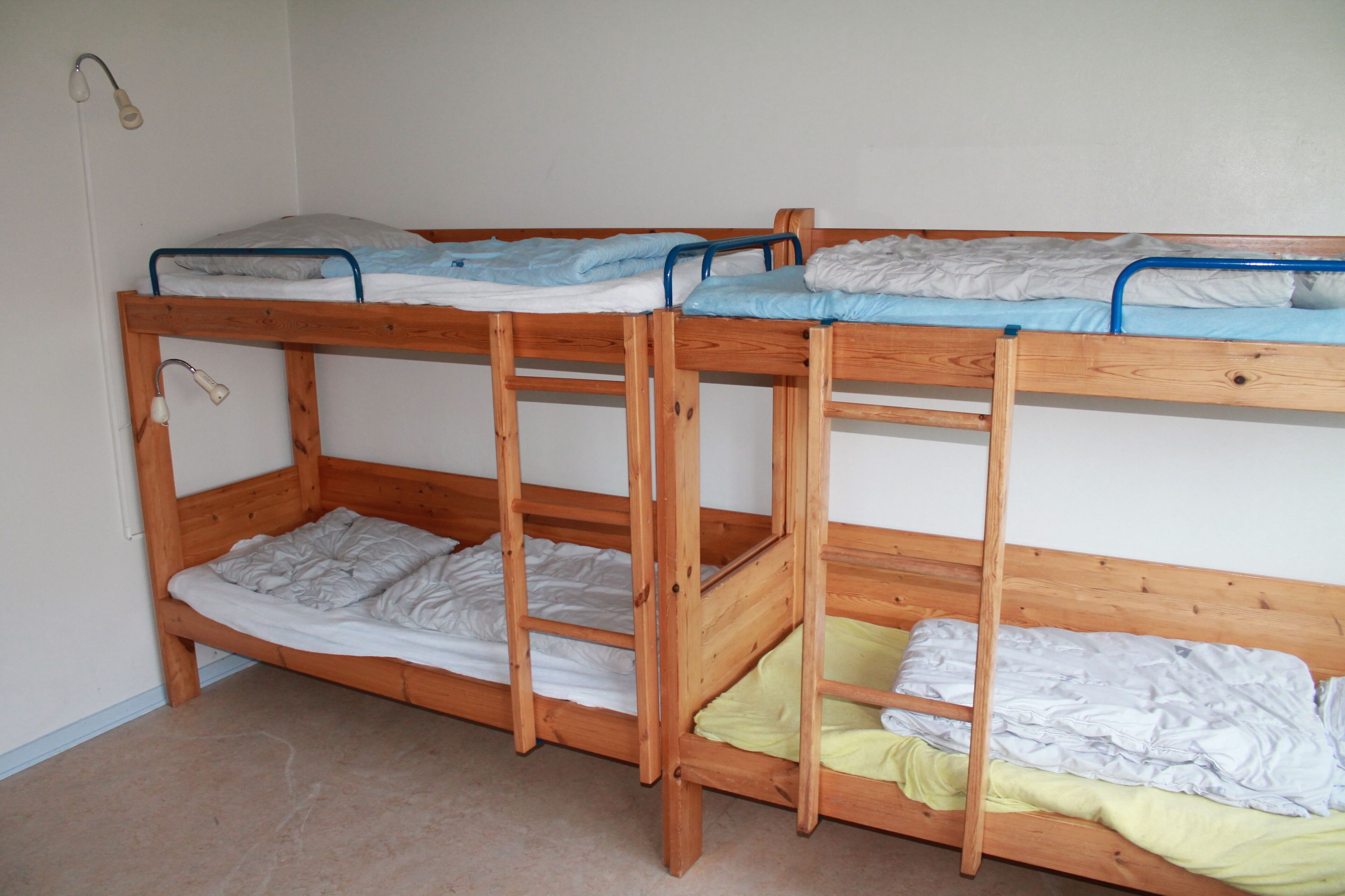 Ein Stockbett mit zwei Liegeflächen, jeweils mit einer Matratze und einem Kopfkissen.