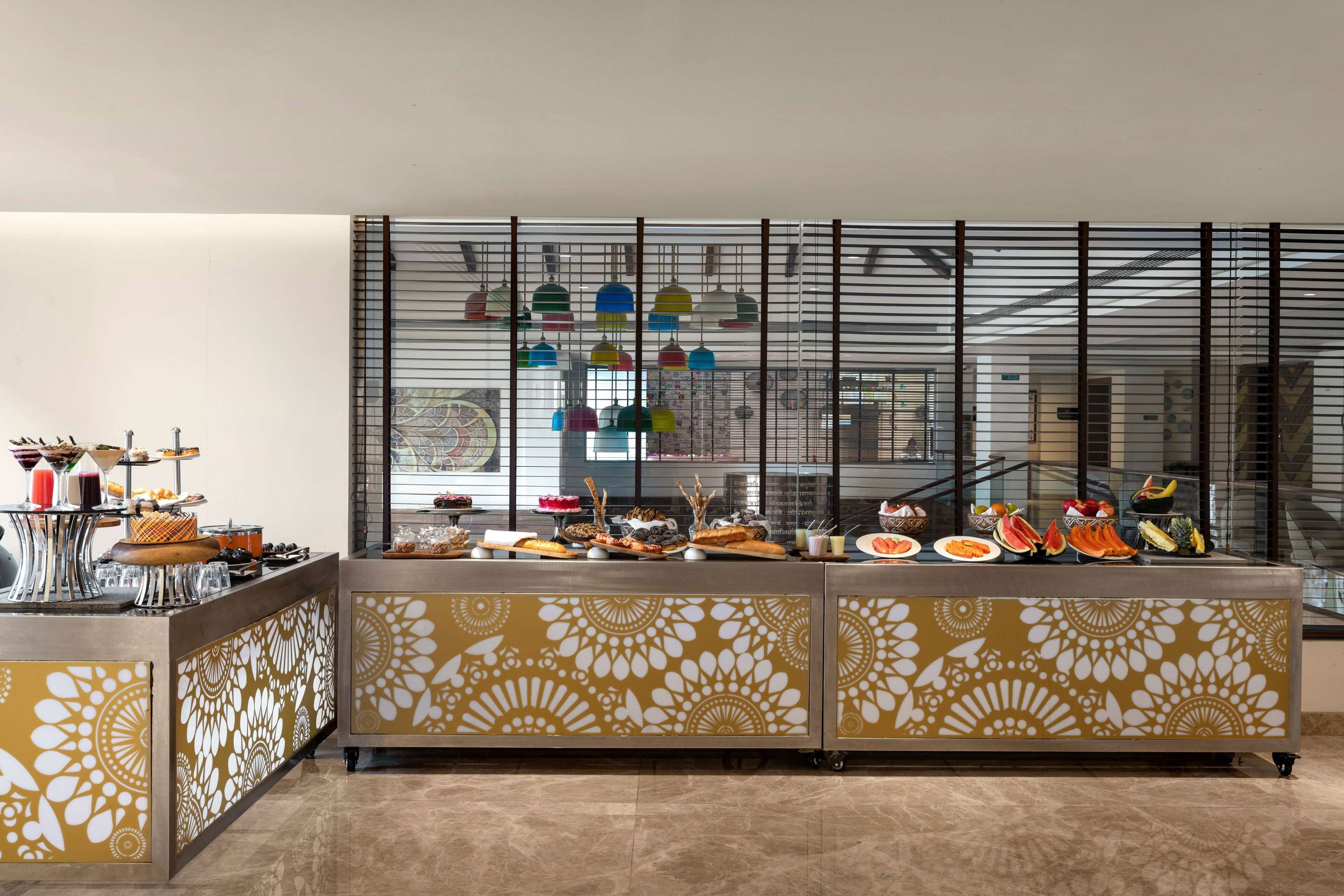 Zona de bufé con diversas opciones de comida y un separador decorativo con estampado floral.