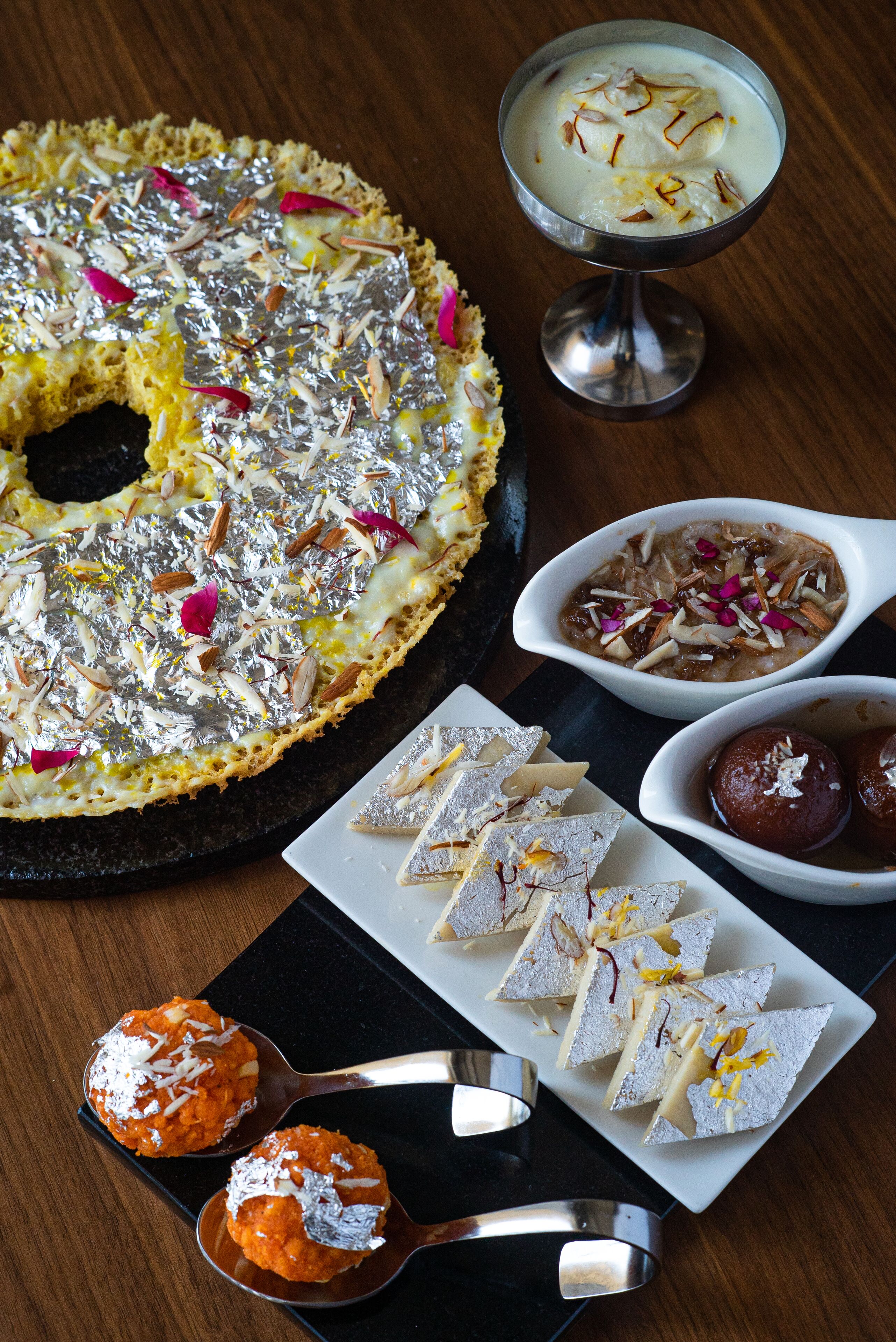 A dessert platter with various sweets and a bowl of milk-based dessert.