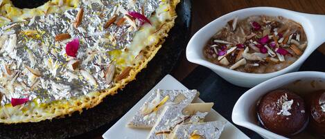 Um prato de sobremesas com diversos doces e uma tigela de doce à base de leite.