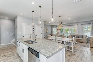 Enjoy cooking in this well-equipped kitchen with a large island, dishwasher, and stainless steel sink.