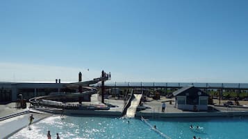 Ein Schwimmbecken mit Wasserrutsche und Rettungsschwimmerstation.