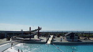 Ein Schwimmbecken mit Wasserrutsche und Rettungsschwimmerstation.
