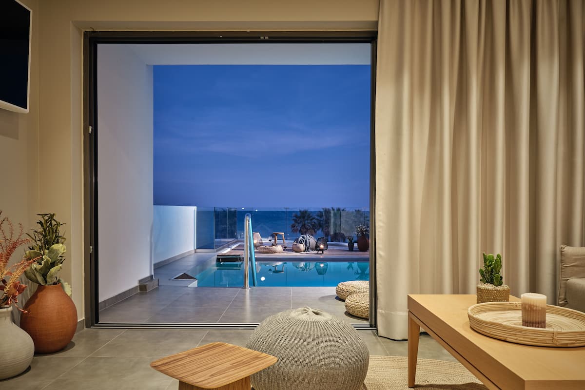 Una sala de estar moderna con una puerta de vidrio que da a una zona de piscina.