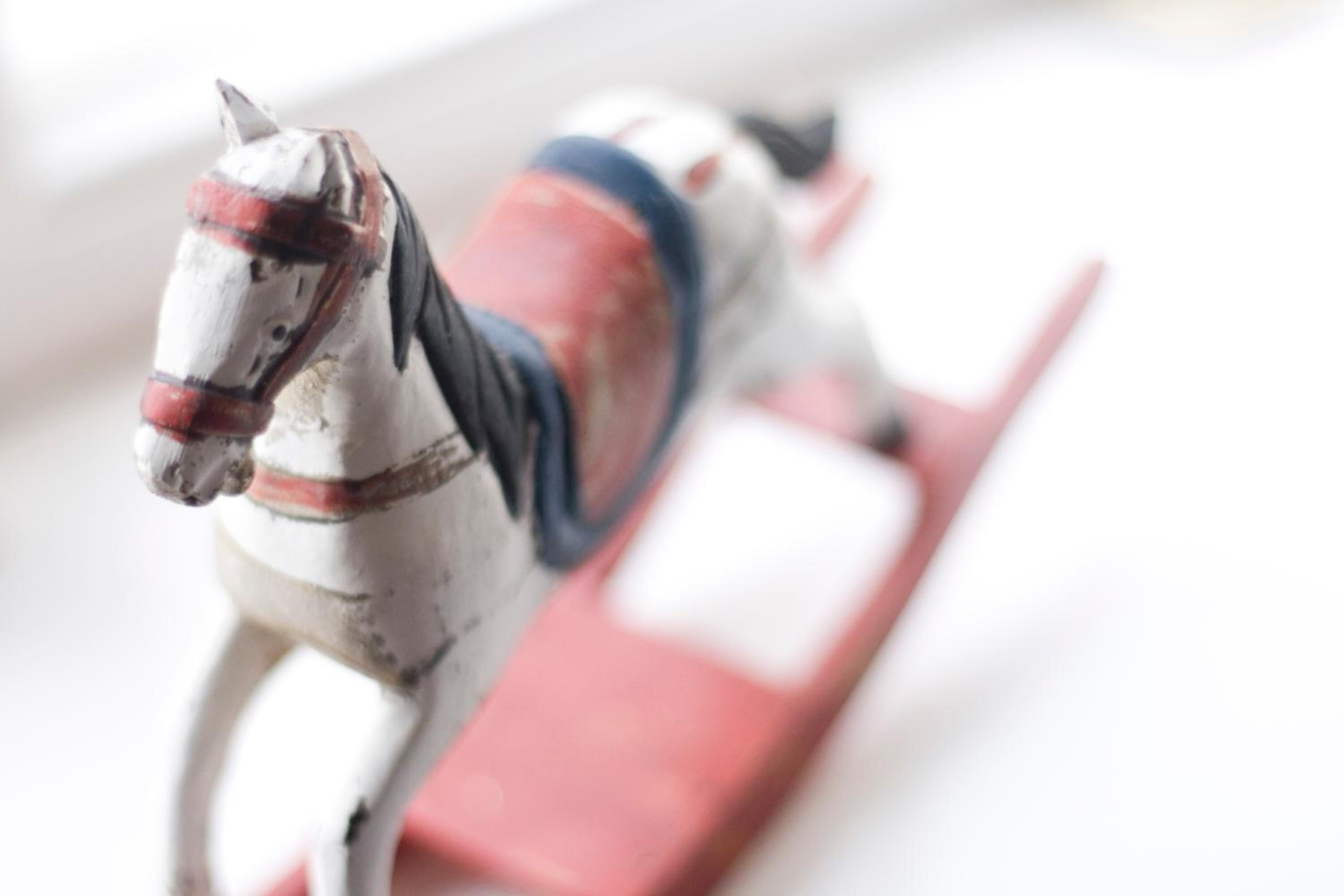 A toy horse on a red and white platform.