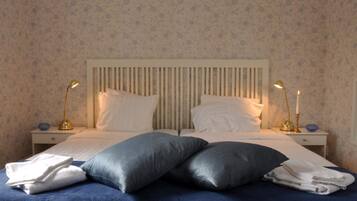 A neatly made bed with two pillows and two bedside lamps.