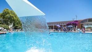 Une piscine dotée d’un grand parasol pour créer de l’ombre.