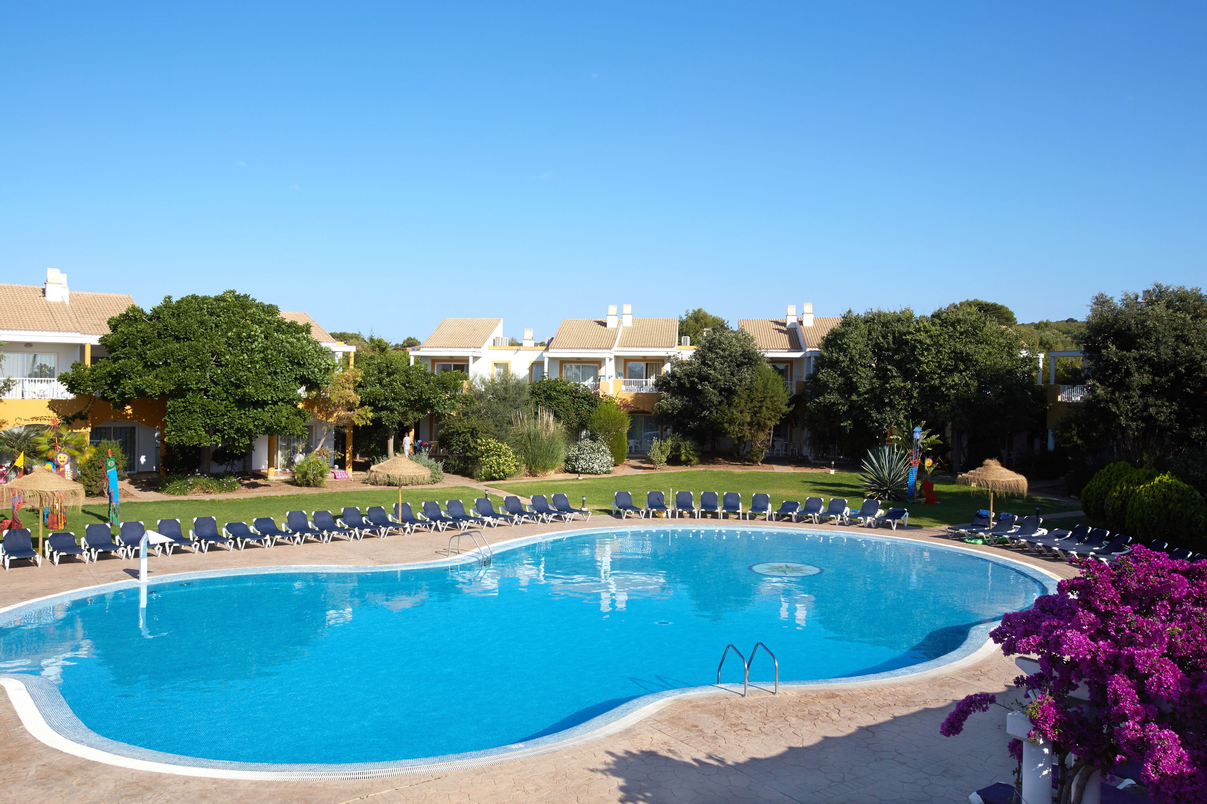 Een buitenzwembad, ligstoelen bij het zwembad