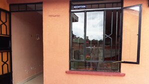 A reception area with a glass door and a sign above it. - Eastward Garden Hotel (Nyahururu)