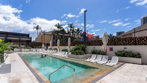 A swimming pool with lounge chairs and a lifeguard stand. - Surferparadise Gem+parkingflexible Refund (Surfers Paradise)