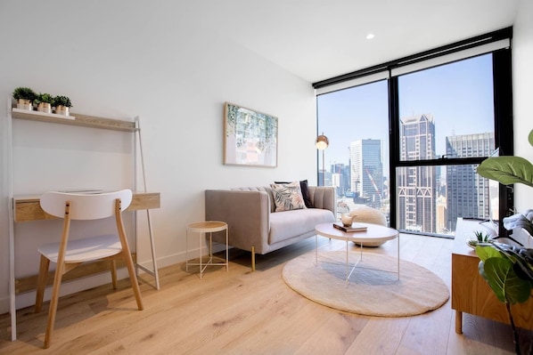 Relax in a spacious living room with a city view, comfortable sofa, and natural light.