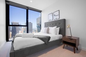 Relax in a spacious room with a large bed, nightstand, and city views.