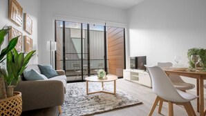 A modern living room with a sofa, coffee table, and dining area. - Elegant Stylish Living@mooneeponds Wifi/parking (Moonee Ponds)