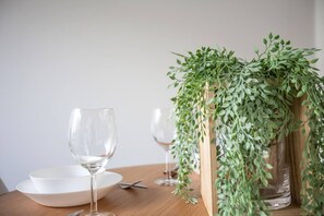 A dining table with two wine glasses, a white bowl, and a potted plant. - Elegant Stylish Living@mooneeponds Wifi/parking (Moonee Ponds)