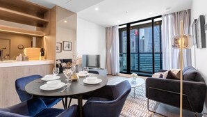 Un soggiorno moderno con zona pranzo, un divano e una televisione.