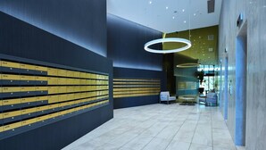 A modern lobby with a row of yellow lockers, a seating area, and a glass partition. - Ultimate Prestige 2bed2bath Hamiltonapt (Hamilton)