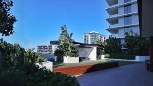 A modern building with a flat roof, surrounded by greenery and a clear blue sky. - Ultimate Prestige 2bed2bath Hamiltonapt (Hamilton)