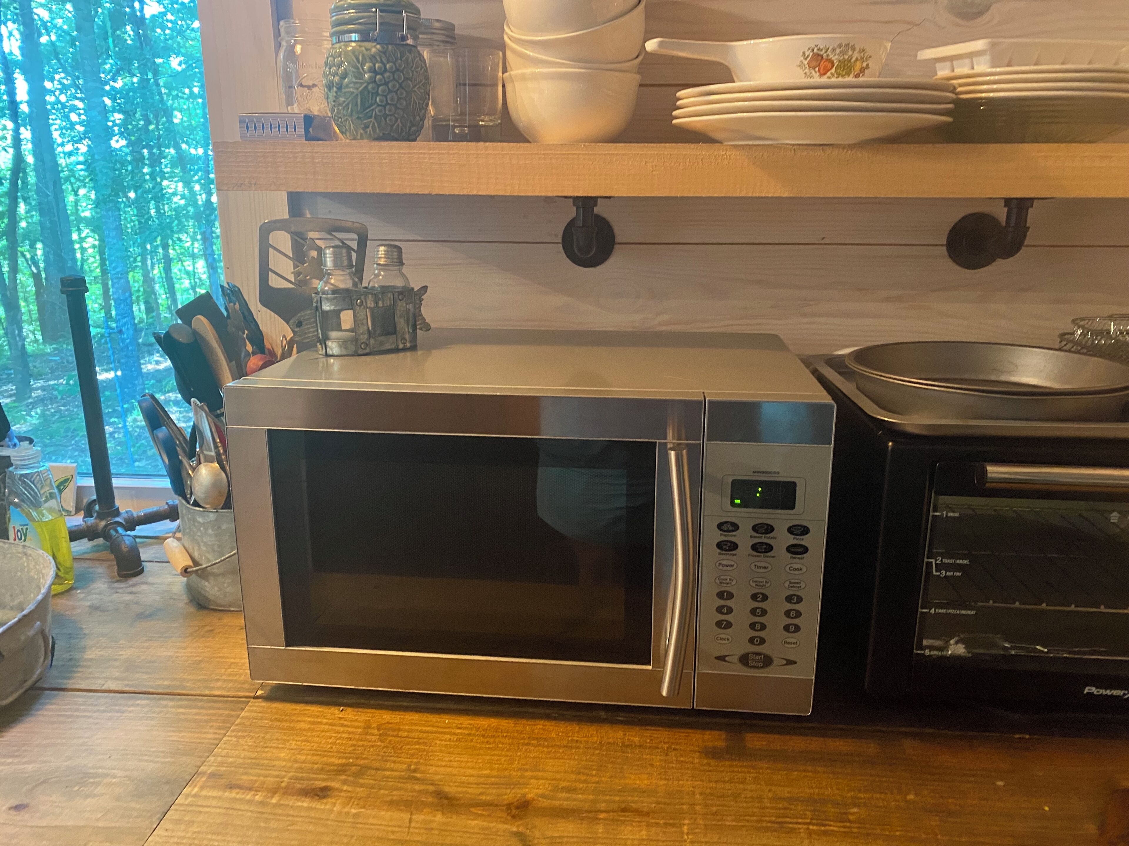 Une cuisine équipée d’un four à micro-ondes, d’un grille-pain et d’une bouilloire, le tout posé sur le plan de travail.