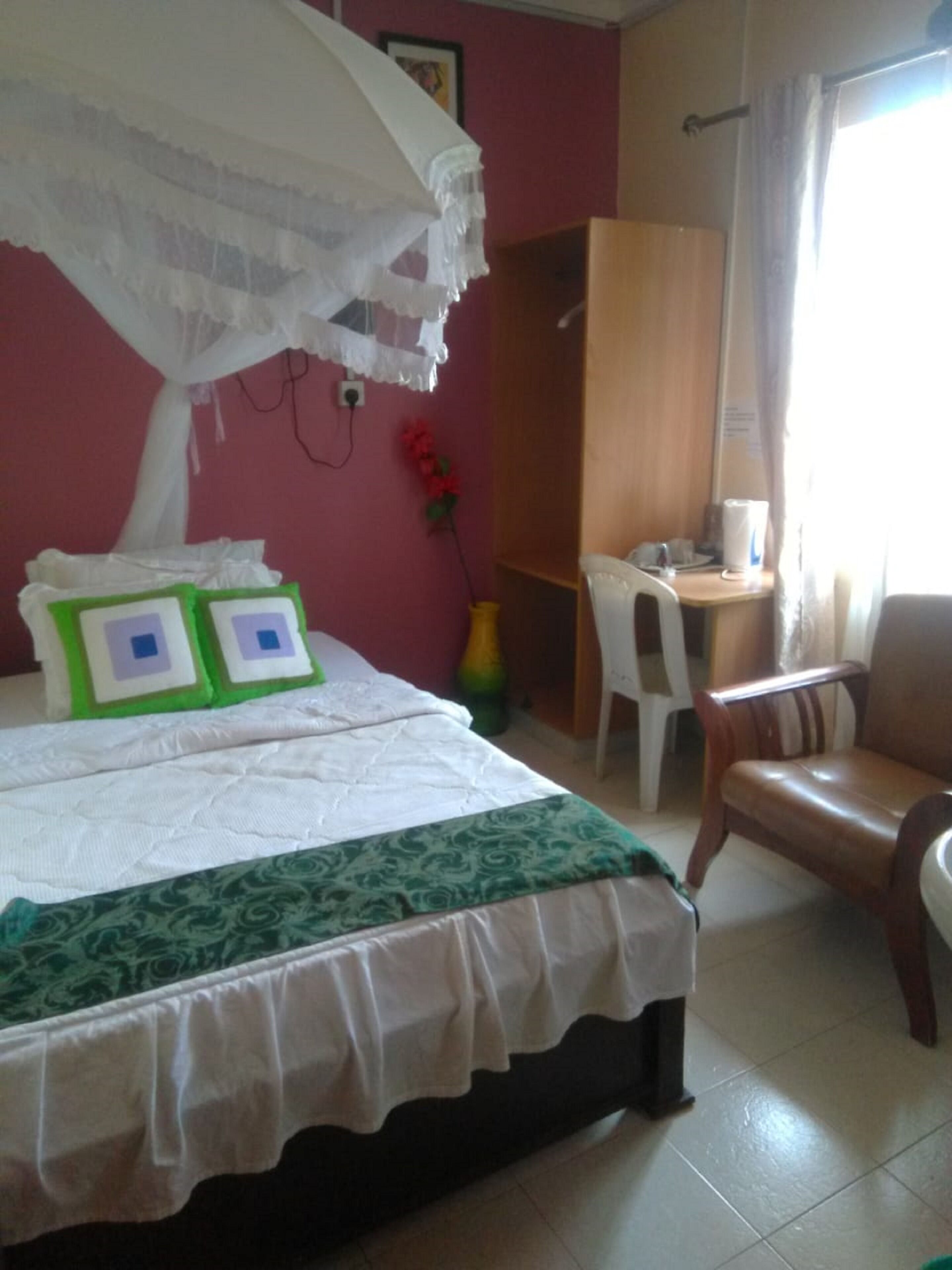 A room with a bed, a desk, a chair, and a wardrobe.