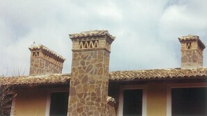 A building with two chimneys and a stone pillar.