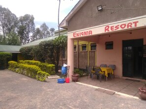 A building labeled "ENIGMA RESORT" with outdoor seating and potted plants. - Enigma Resort (Kisumu)