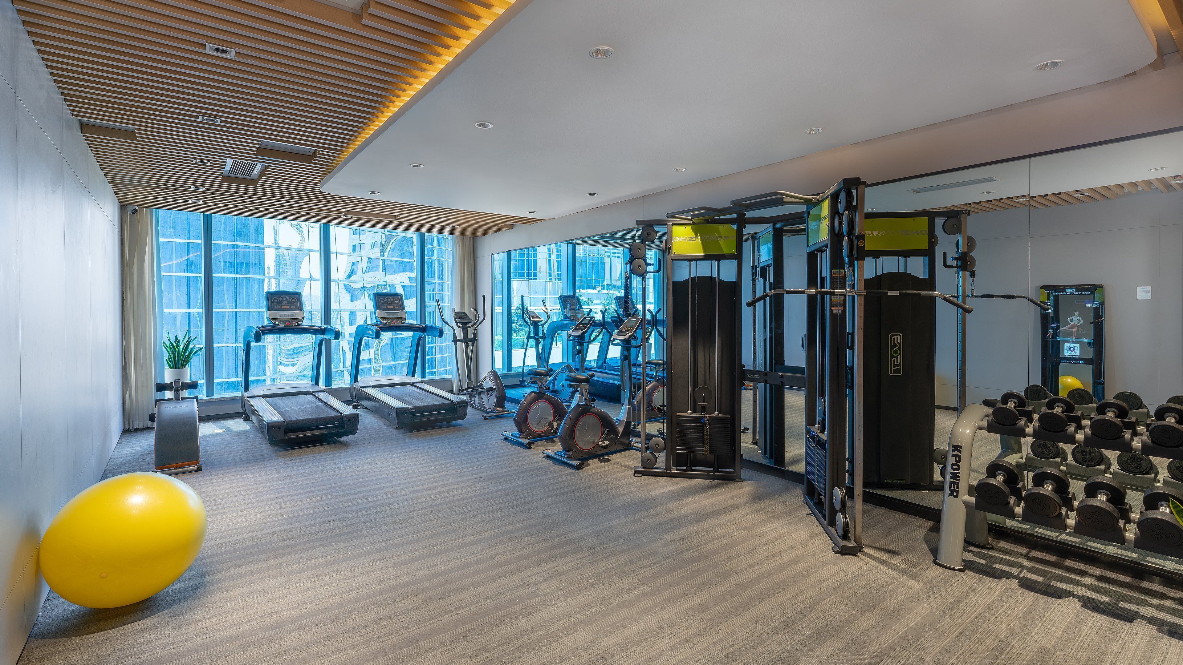 A gym with treadmills, exercise bikes, and weightlifting equipment.