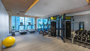 Uma academia com esteiras, bicicletas ergométricas e equipamentos de musculação.