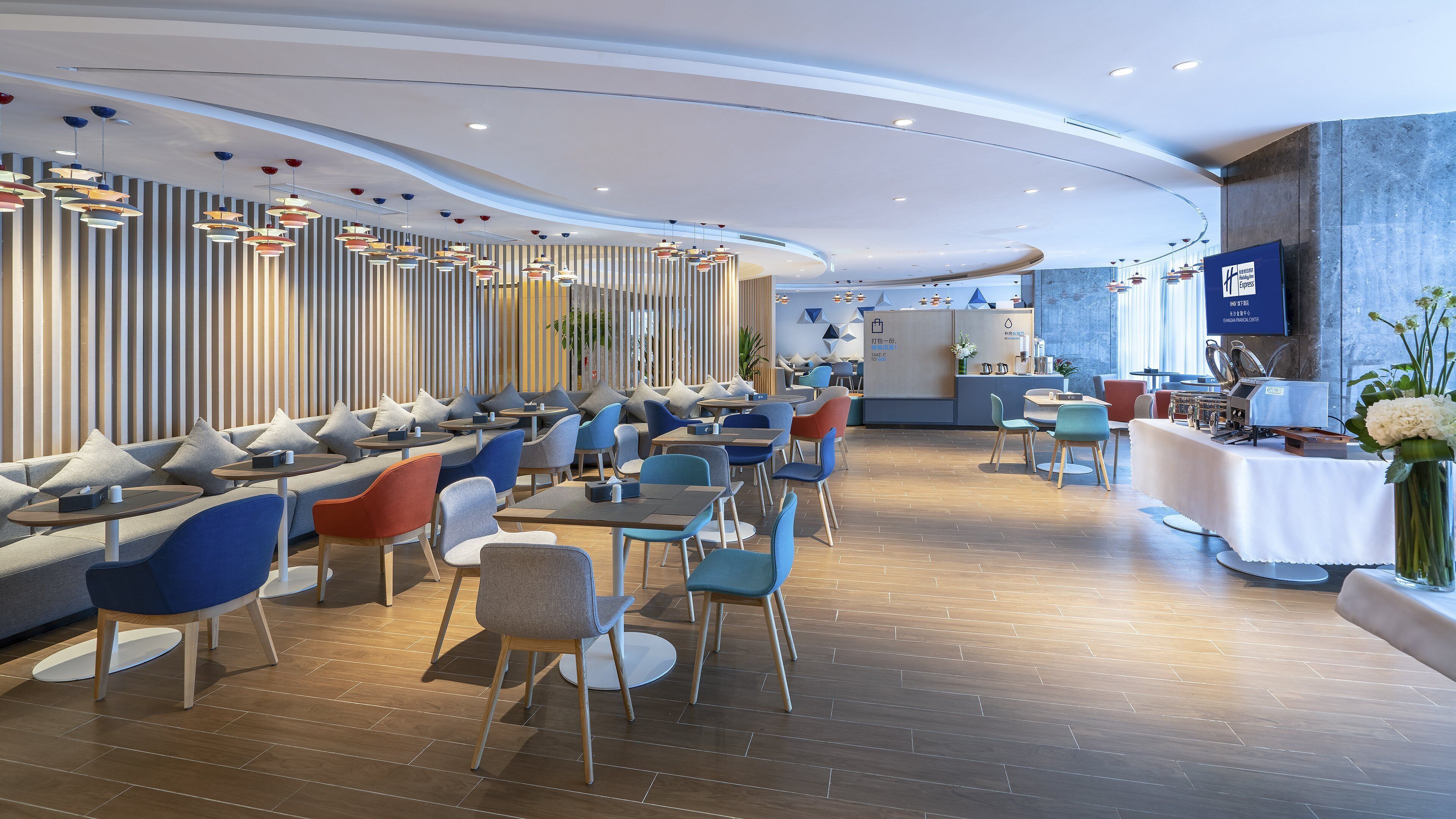 Un restaurante moderno con diversas opciones de asientos, incluyendo mesas y cabinas, y una zona de bar con mostrador.