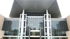 A modern building with a large glass facade and a prominent white structure in the center. - Holiday Inn Express Changsha Wuyi Plaza by IHG (Changsha)