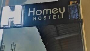A sign for 'Homey Hostel' with a large 'H' and the name 'Homey Hostel' in white letters on a dark background. - Homey Hostel, Ipoh Town (Ipoh)