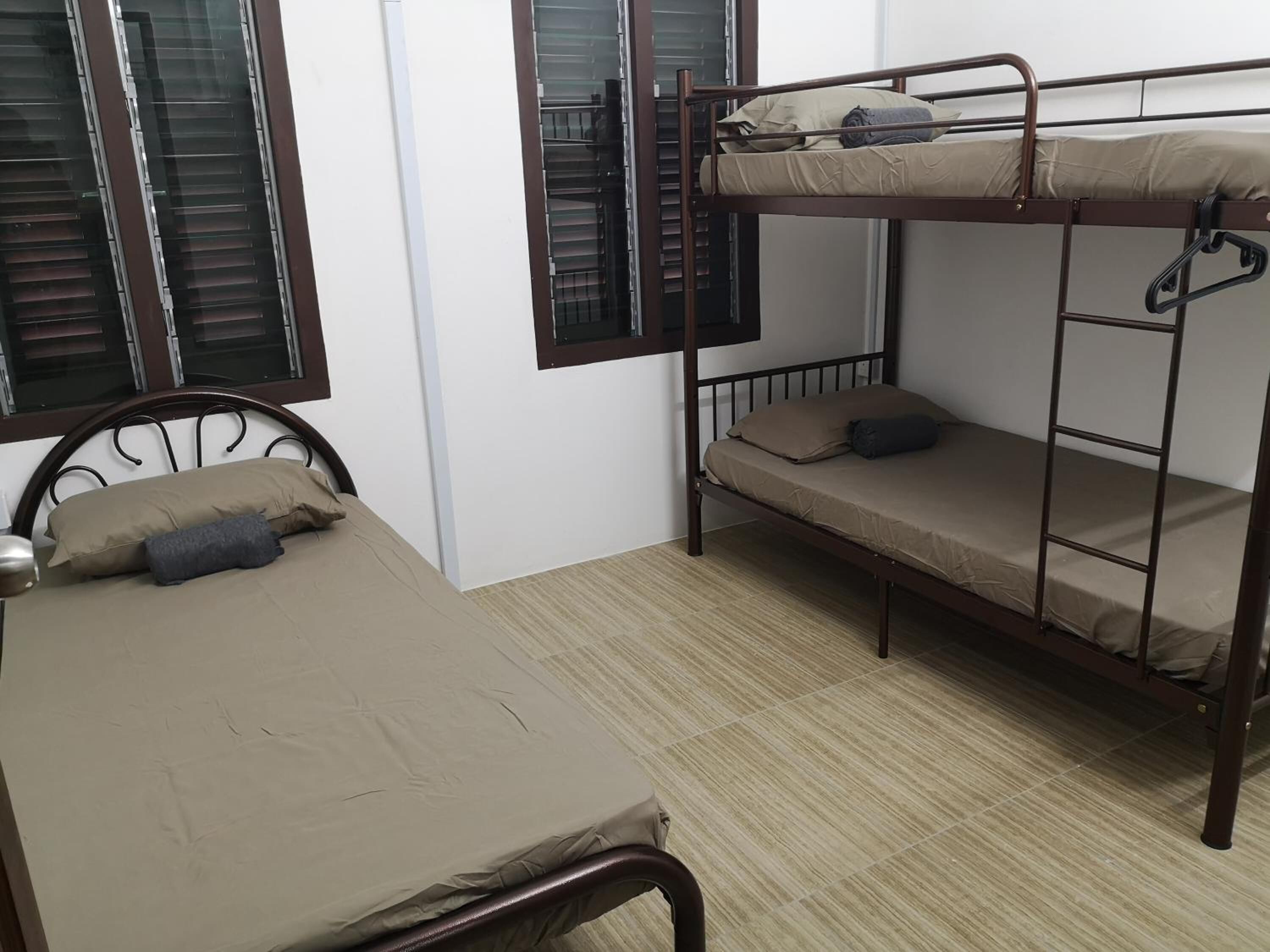 A dormitory room with a bunk bed and a single bed.